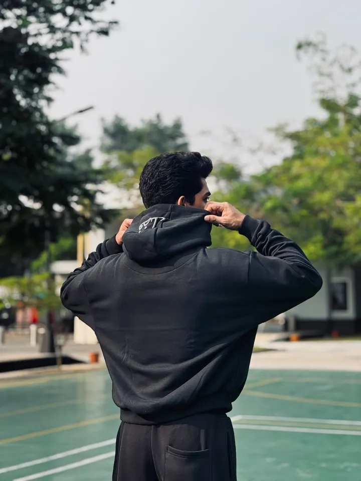 Back view of the black FAZAL hoodie showing the embroidered hood logo