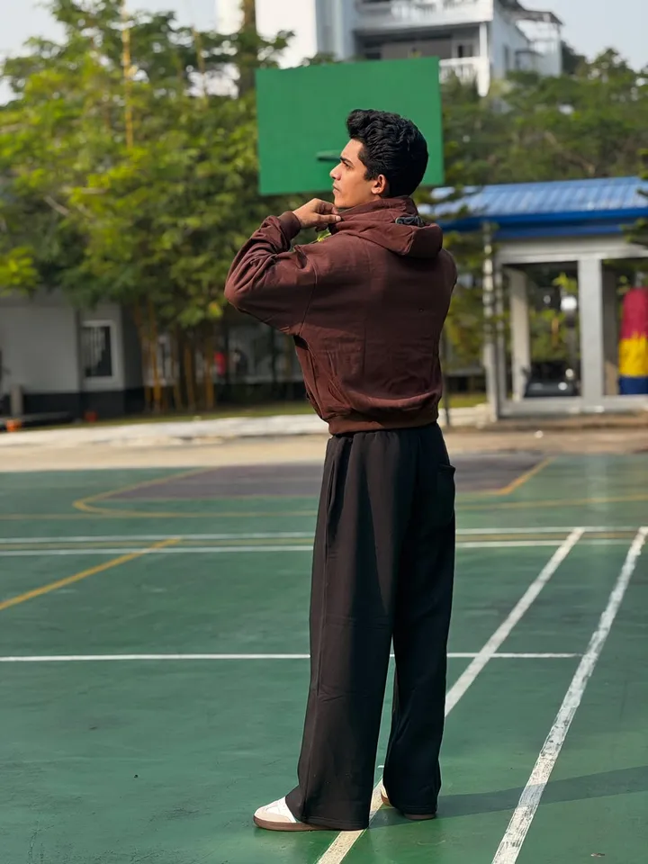 Model from behind in the brown FAZAL hoodie and black trouser